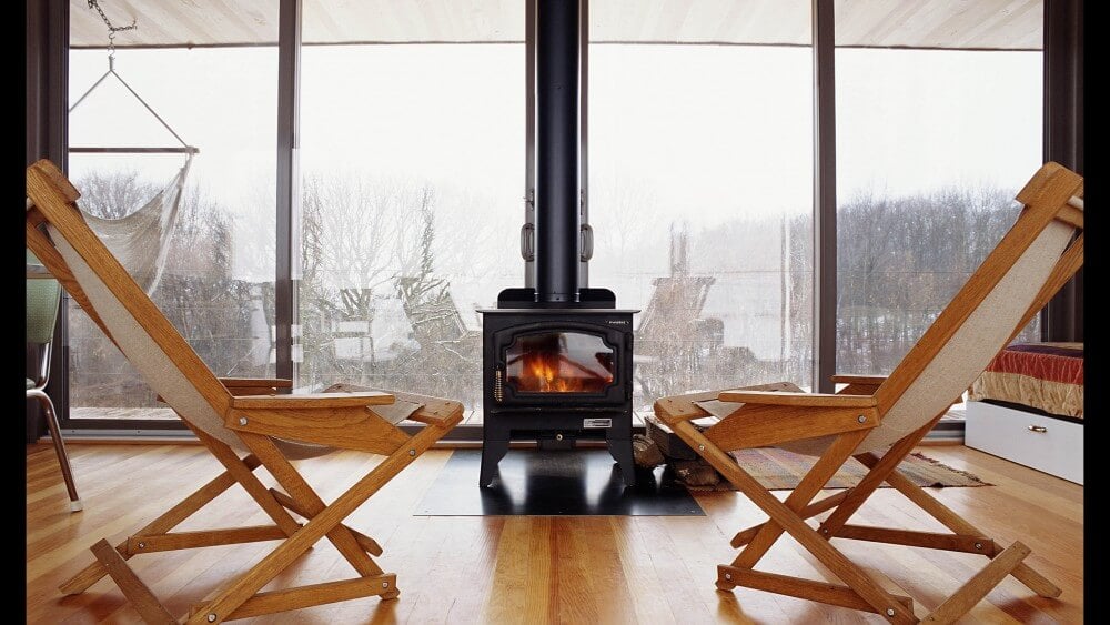 正面的黑色取暖炉，坐在中央靠后庭院门上的硬木地板。