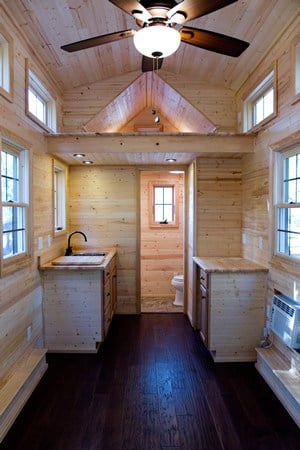 迷你住宅的内部空间最大化，小厨房旁边有小浴室。浅色天然木材覆盖深色硬木地板。