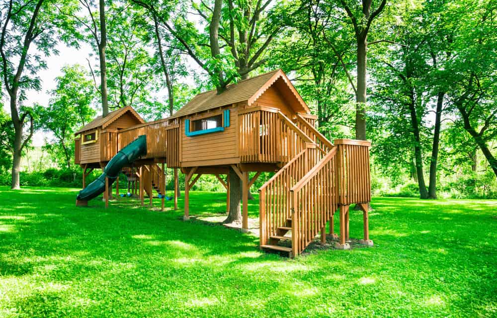Incredible playhouse structure that is two playhouses connected by bridge and includes a slide.