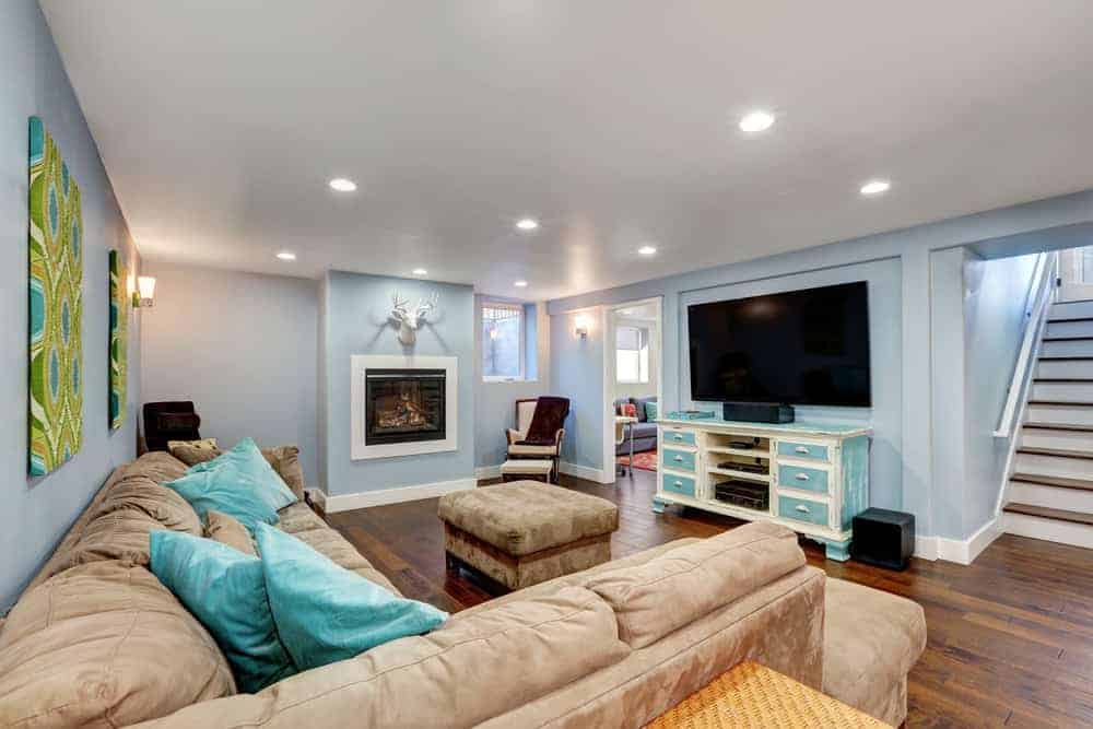 漂亮完成的地下室，电视，沙发和柔软的蓝色墙壁。