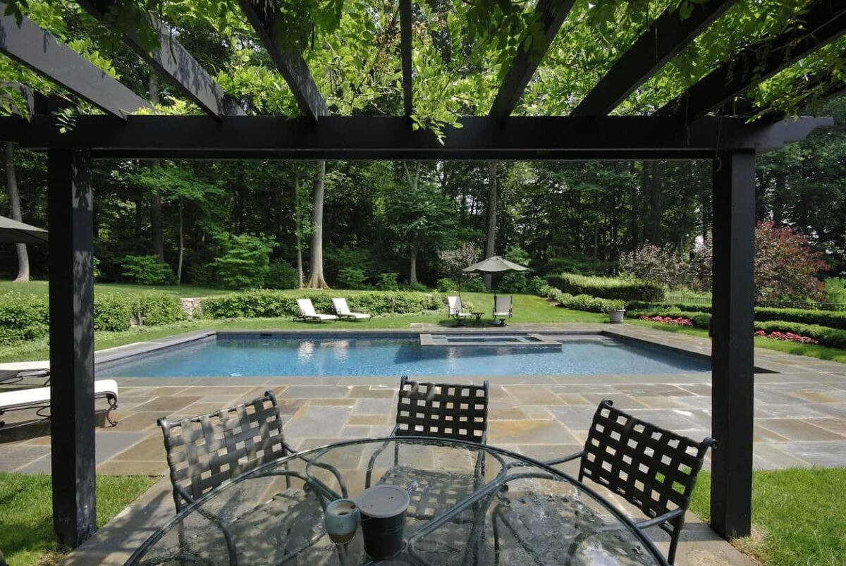 大型树木后院，矩形泳池周围环绕着一个神话般的多色露台。
