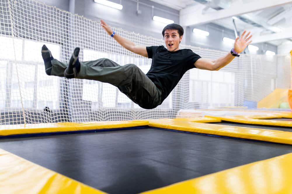 A guy playing on a trampoline in a fly park.