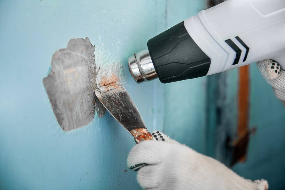 使用除漆工具清除墙上的旧油漆。