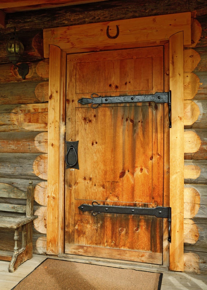 工匠前门与金属五金伴随壁灯和黄麻地毯。旁边有一张质朴的长凳，与大木梁融为一体。