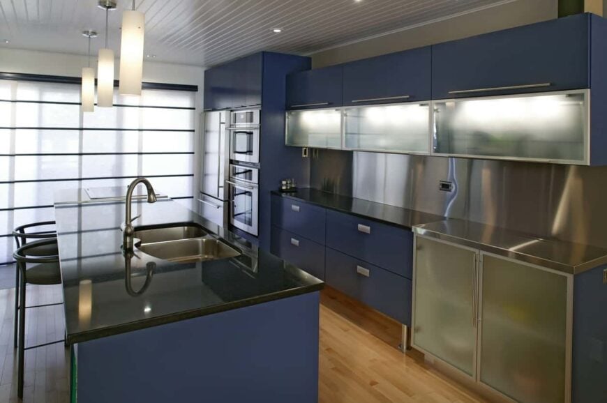 看着这个厨房，你马上就能看出它散发着专业的才华，就好像它是由厨师拥有的一样。它有明亮的哑光蓝色橱柜，具有现代美学，与不锈钢元素和黑色台面完美搭配。
