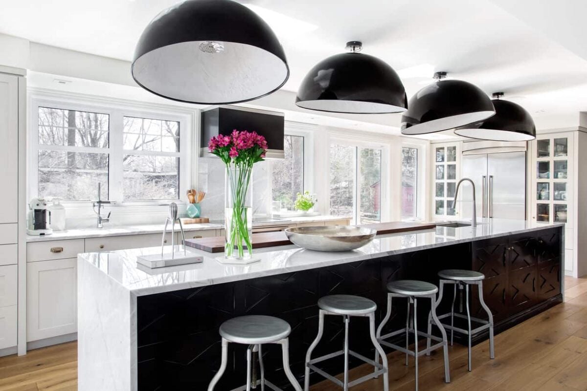 现代厨房设计，黑色吊灯，大量窗户，长岛早餐吧。