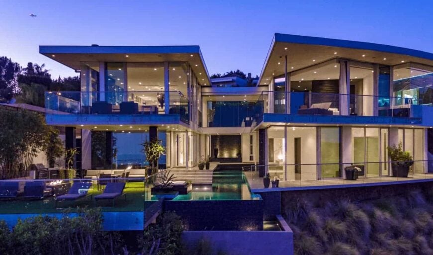 一个豪华的当代豪宅，拥有优秀的玻璃面板工作，令人惊叹的水景和一个宁静的游泳池，作为房子的中心亮点。