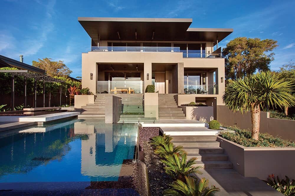 一个与周围环境完全融合的现代房子。它的外观具有尖锐的结构设计，伴随着一个度假风格的花园，以分层景观和一个令人惊叹的无边泳池为特色。