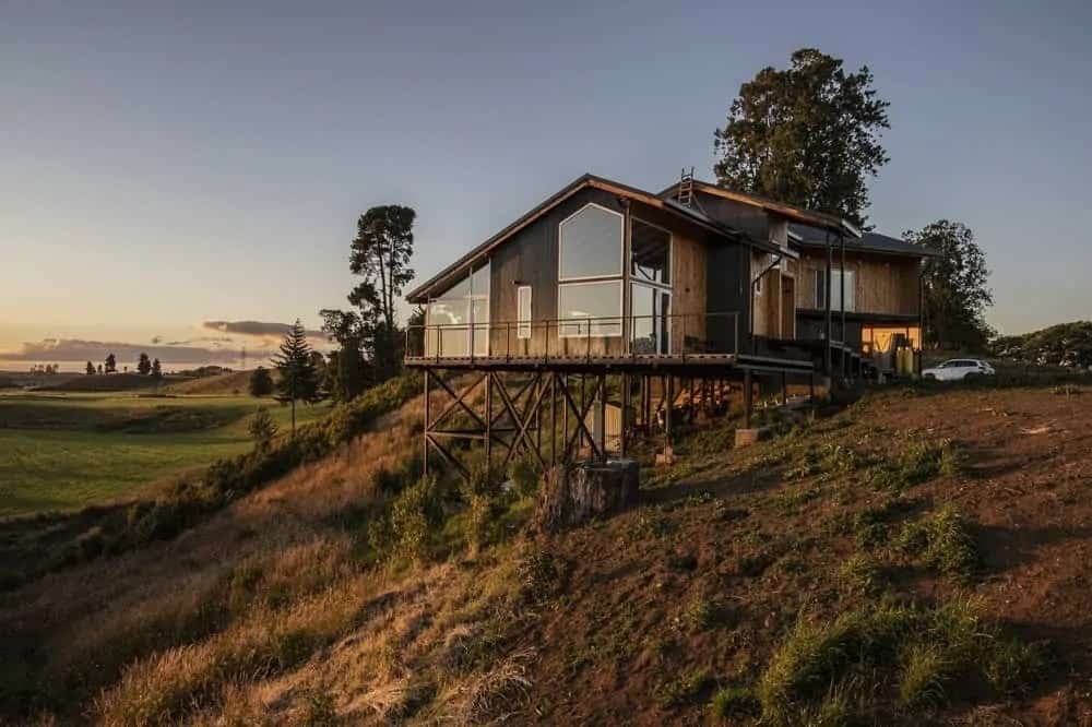这是一个宁静的家，坐落在一个斜坡上，俯瞰着一个广阔的平原。住宅的大玻璃窗和玻璃墙将这一景观最大化，提升了住宅外部的乡村氛围。