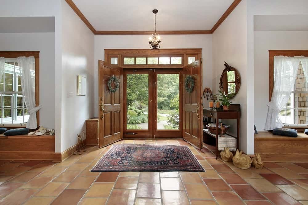 一个豪华的门厅与陶土瓷砖和有图案的区域地毯。