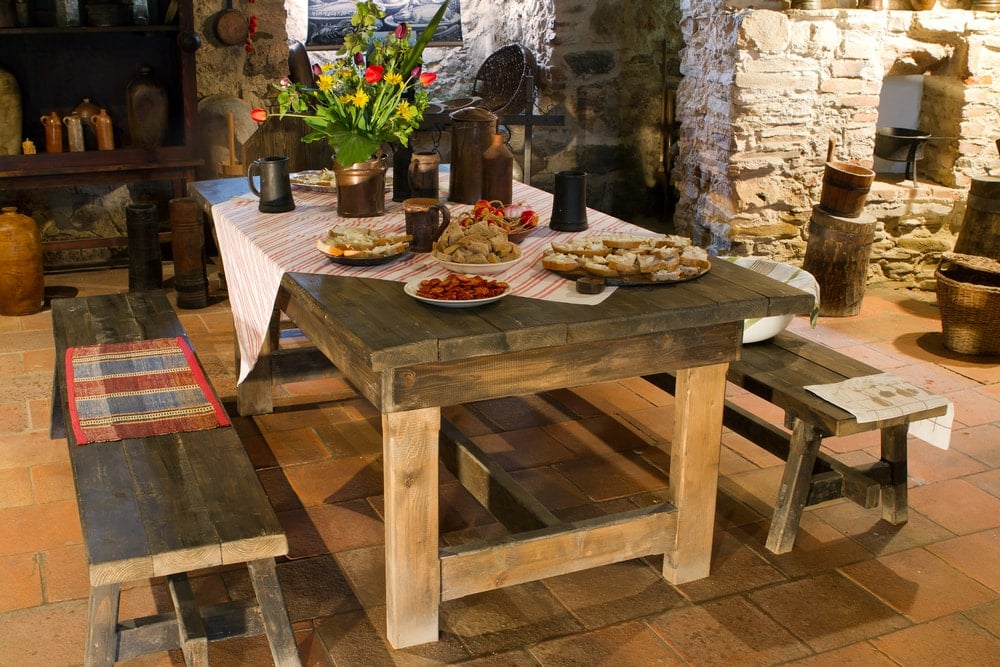一个可爱的乡村餐桌搭配相配的木长椅上的陶土地板瓷砖。