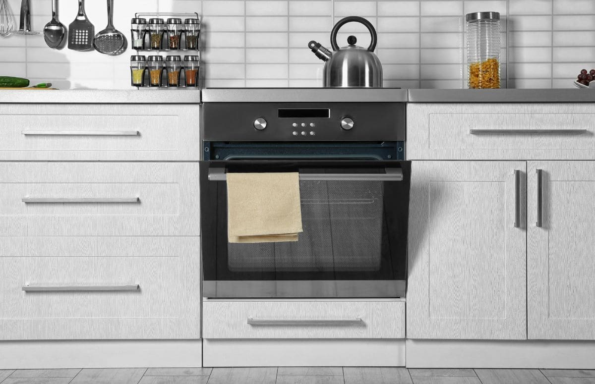 现代厨房，白色橱柜和黑色和银色烤箱