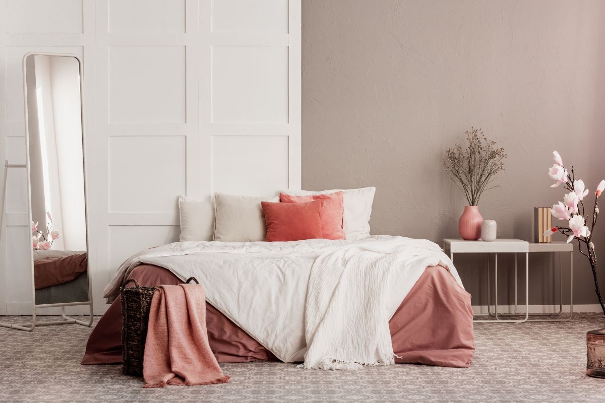 最小的卧室，灰褐色的墙壁和粉红色的床上用品和细节