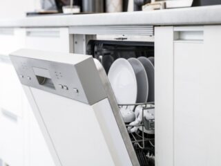 一张打开的洗碗机的照片，里面有一些盘子和餐具，