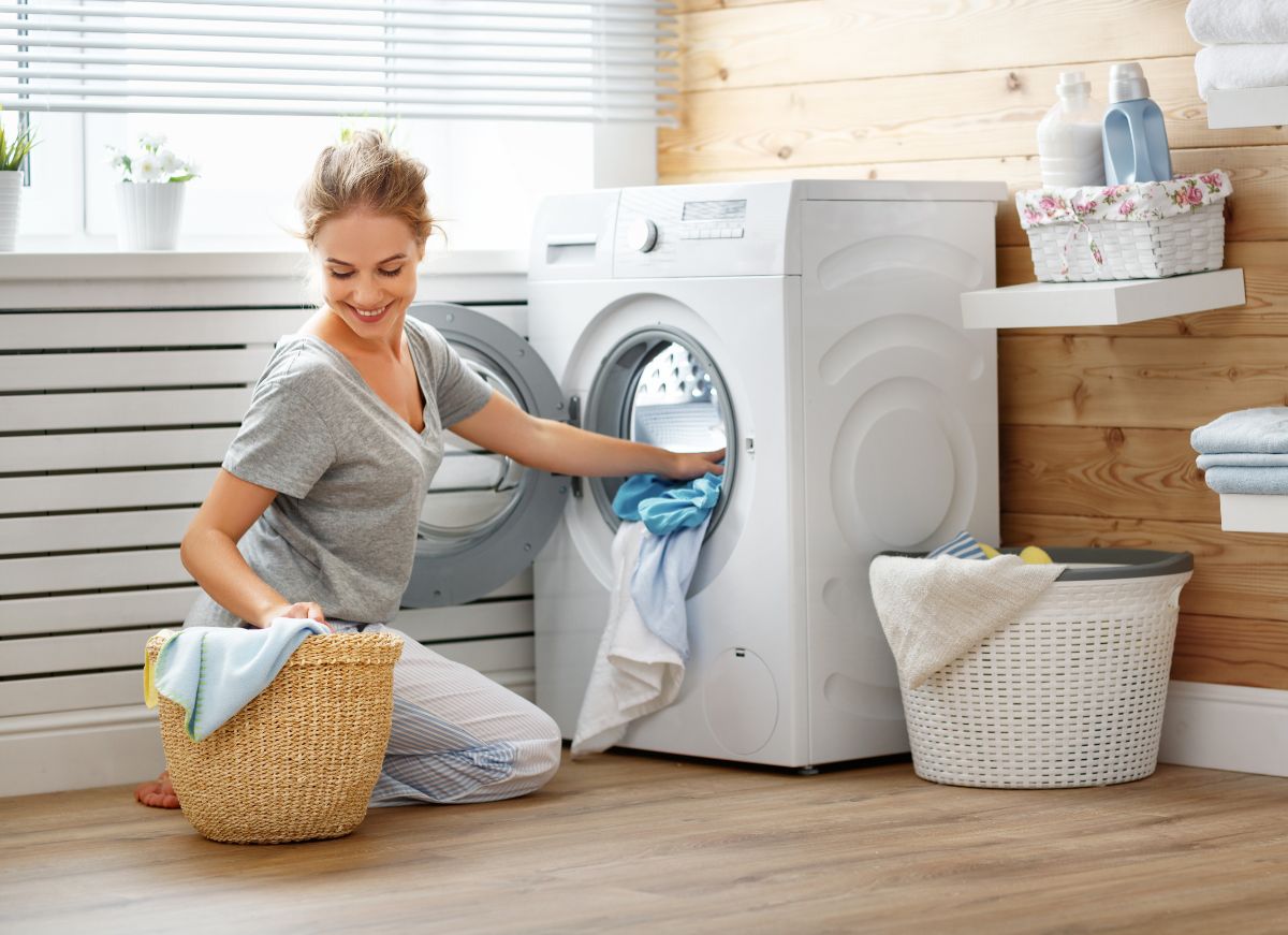 一个女人从洗衣机里取出要洗的衣服。