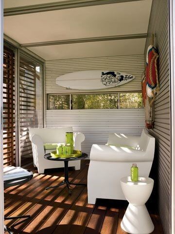Kithaus内部冲洗与明亮的白色家具，黑色的桌子和细节，如冲浪板和墙壁上的寿命。