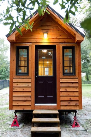 这是一个相同的小房子，坐落在一个更传统的院子里。黑色的门窗与外部形成对比。
