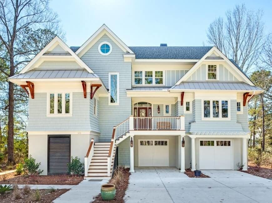木瓦、木板和板条与白色和红木的结合创造了这栋房子的华丽外观。有时，结合外部覆盖风格是创造出最好的家庭设计的方法。