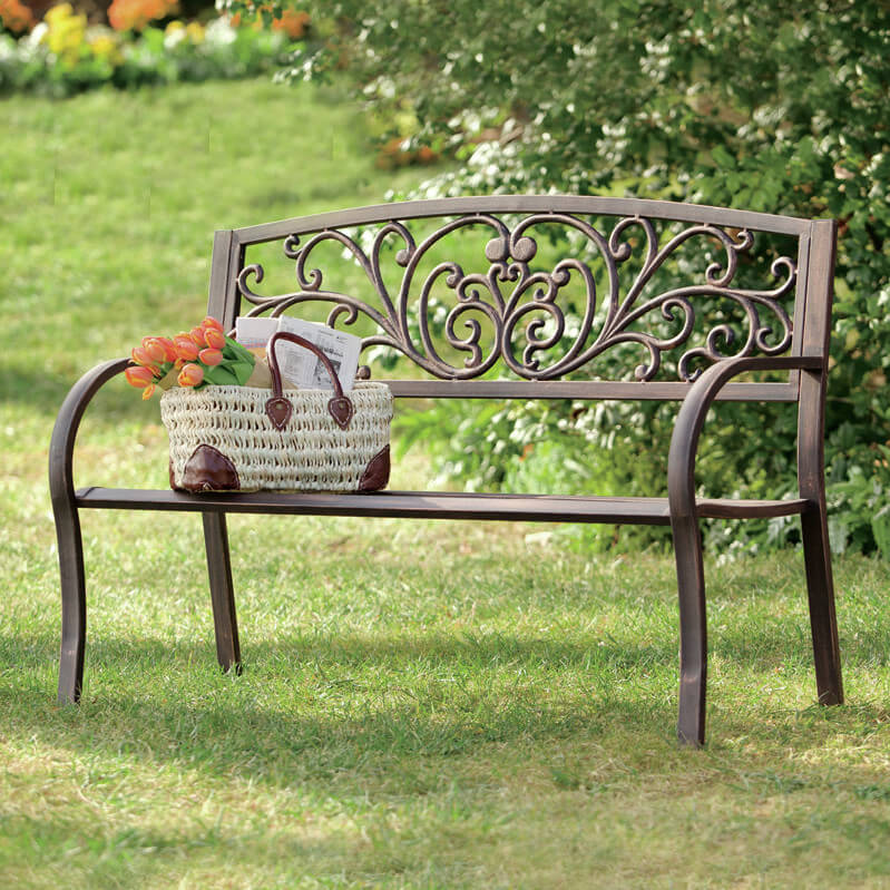 一个优雅的锻铁长凳，滚动式装饰靠背。这件作品非常适合任何庭院区域或花园。