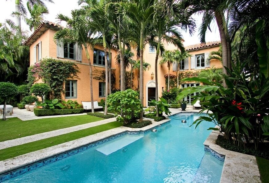 高大的棕榈树框架的走道，通往这个巨大的，优雅的家的后院的巨大游泳池。