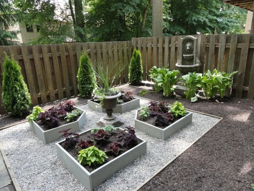 一个容器花园甚至可以由更小的凸起的种植盒组成。这个花园的维护成本很低，它去掉了草坪，使用了覆盖物和鹅卵石，并使用了一些小型的种植床。