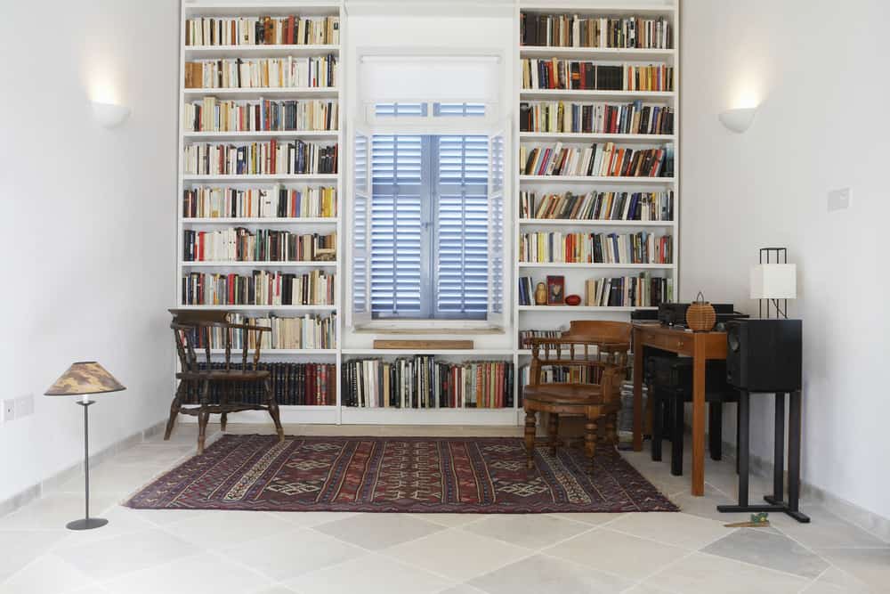 白色墙壁和嵌入式书架的家庭图书馆。
