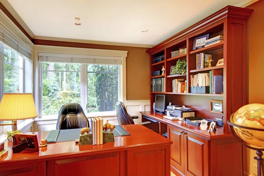 家庭办公室与木制家具和大窗户。