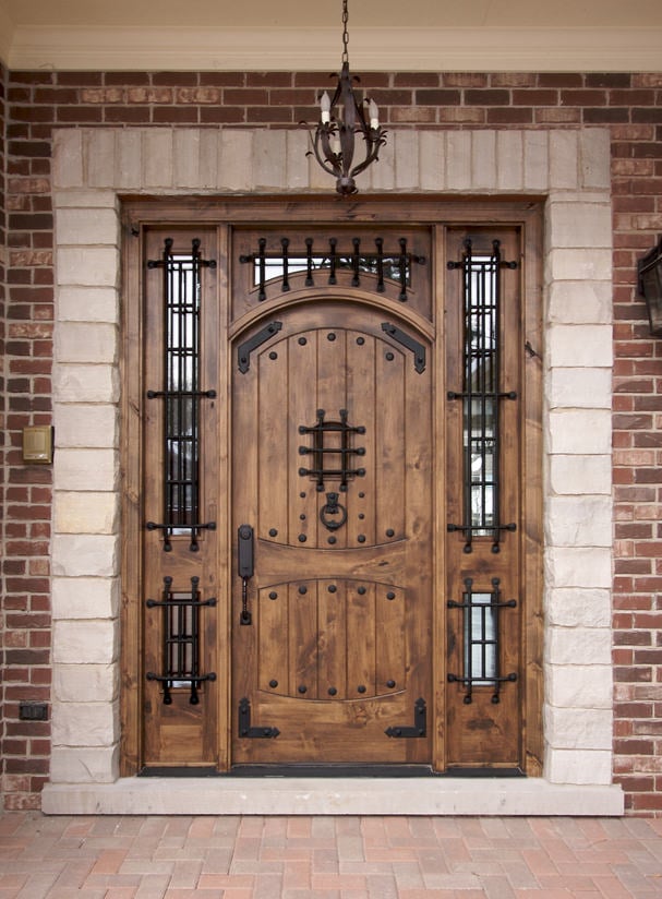 一扇让我们想起中世纪的经典木门。它配有玻璃嵌件和铁艺五金，与老式吊灯相匹配。