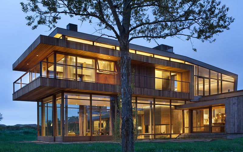 一个大型现代化的房子，拥有温暖的内饰和华丽的外观，带玻璃窗，门和轨道。设有阳台区，户外活动，拥有健康的草坪区域。