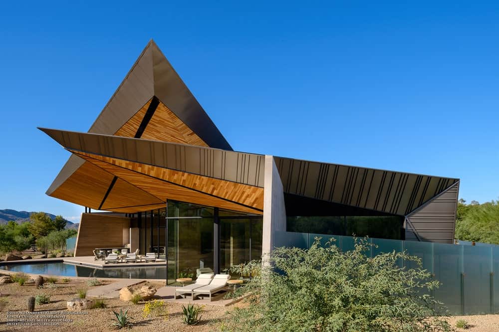 一个引人注目的房子通过其几何形状和浮动的屋顶雨棚具有独特的特点。它反映了周围的山脉，而沙漠景观完成了外观。