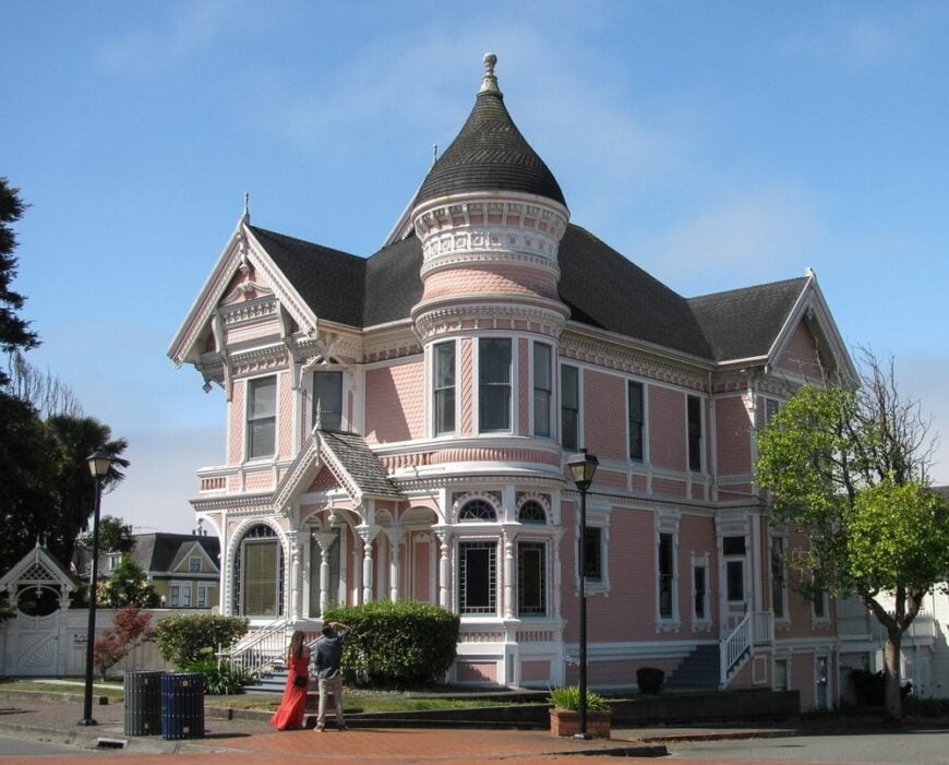 这是一个看起来有一个女王安妮架构的粉红色的房子。