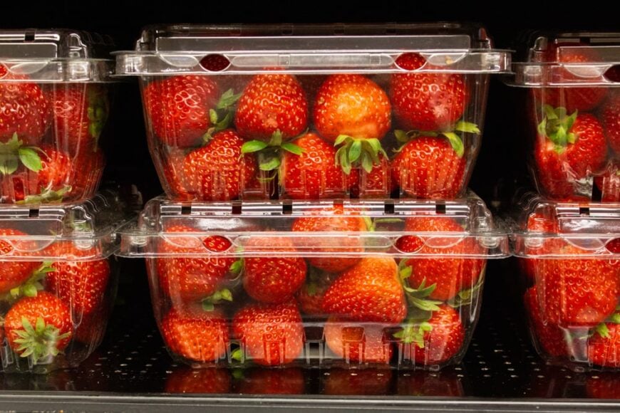 陈列在塑料容器里的成熟草莓。